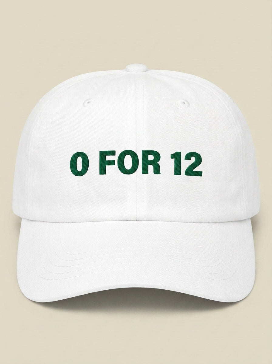 White dad hat embroidered in dark green with 0 FOR 12.
