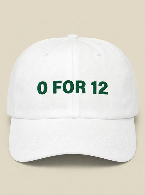 White dad hat embroidered in dark green with 0 FOR 12.