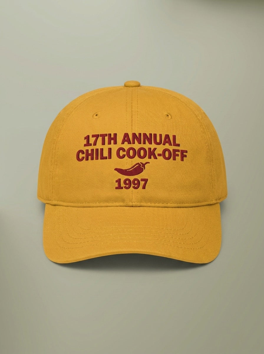 Mustard yellow dad hat embroidered in dark red with 17TH ANNUAL CHILI COOK-OFF, a chili pepper, and 1997.