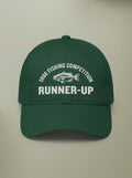 Forest green dad hat embroidered in white with 1996 FISHING COMPETITION curved above a bass, and RUNNER-UP below.