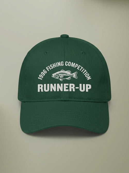 Forest green dad hat embroidered in white with 1996 FISHING COMPETITION curved above a bass, and RUNNER-UP below.