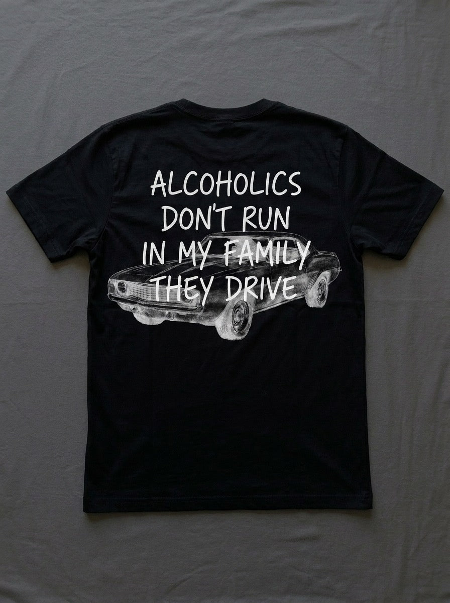 Back of a black t-shirt printed with alcoholics don't run in my family they drive over a parked car.