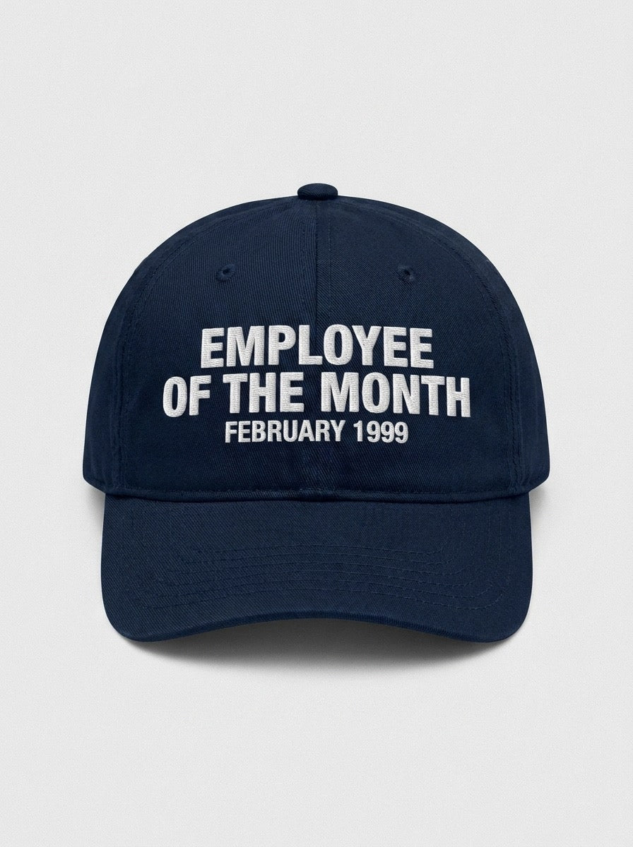 Navy dad hat embroidered in white with EMPLOYEE OF THE MONTH above FEBRUARY 1999.