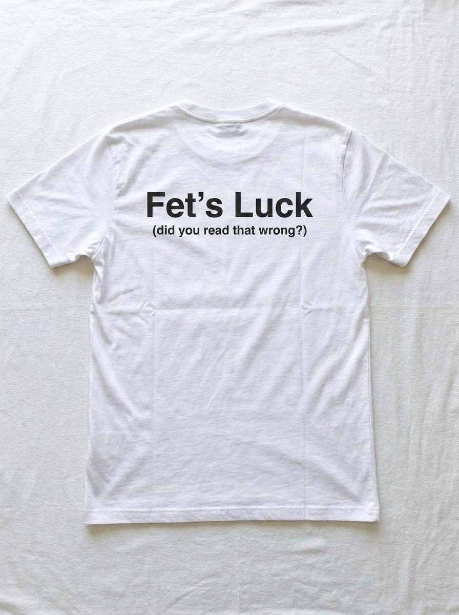 Back of a white t-shirt printed with the words Fet's Luck in large black type, with the line did you read that wrong underneath.