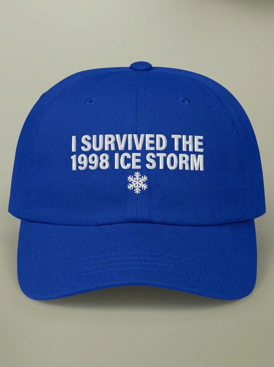 Royal blue dad hat embroidered in white with I SURVIVED THE 1998 ICE STORM above a snowflake.